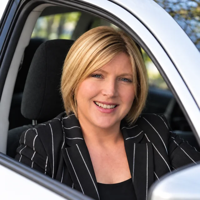 AI-enhanced portrait of Jacqueline Moran smiling from the driver’s seat